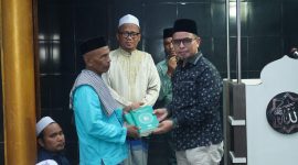 Dr.Sirajudin Lasena Menyerahan Al-Qur’an kepada imam masjid Al-Hidayah desa Kuala, kecamatan Kaidipang. 