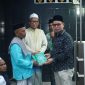 Dr.Sirajudin Lasena Menyerahan Al-Qur’an kepada imam masjid Al-Hidayah desa Kuala, kecamatan Kaidipang. 
