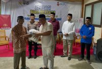 Ketua PWI Boltara Patris Babay menyerahkan bantuan sembako kepada masyarakat