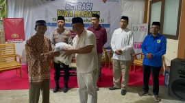 Ketua PWI Boltara Patris Babay menyerahkan bantuan sembako kepada masyarakat
