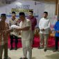 Ketua PWI Boltara Patris Babay menyerahkan bantuan sembako kepada masyarakat